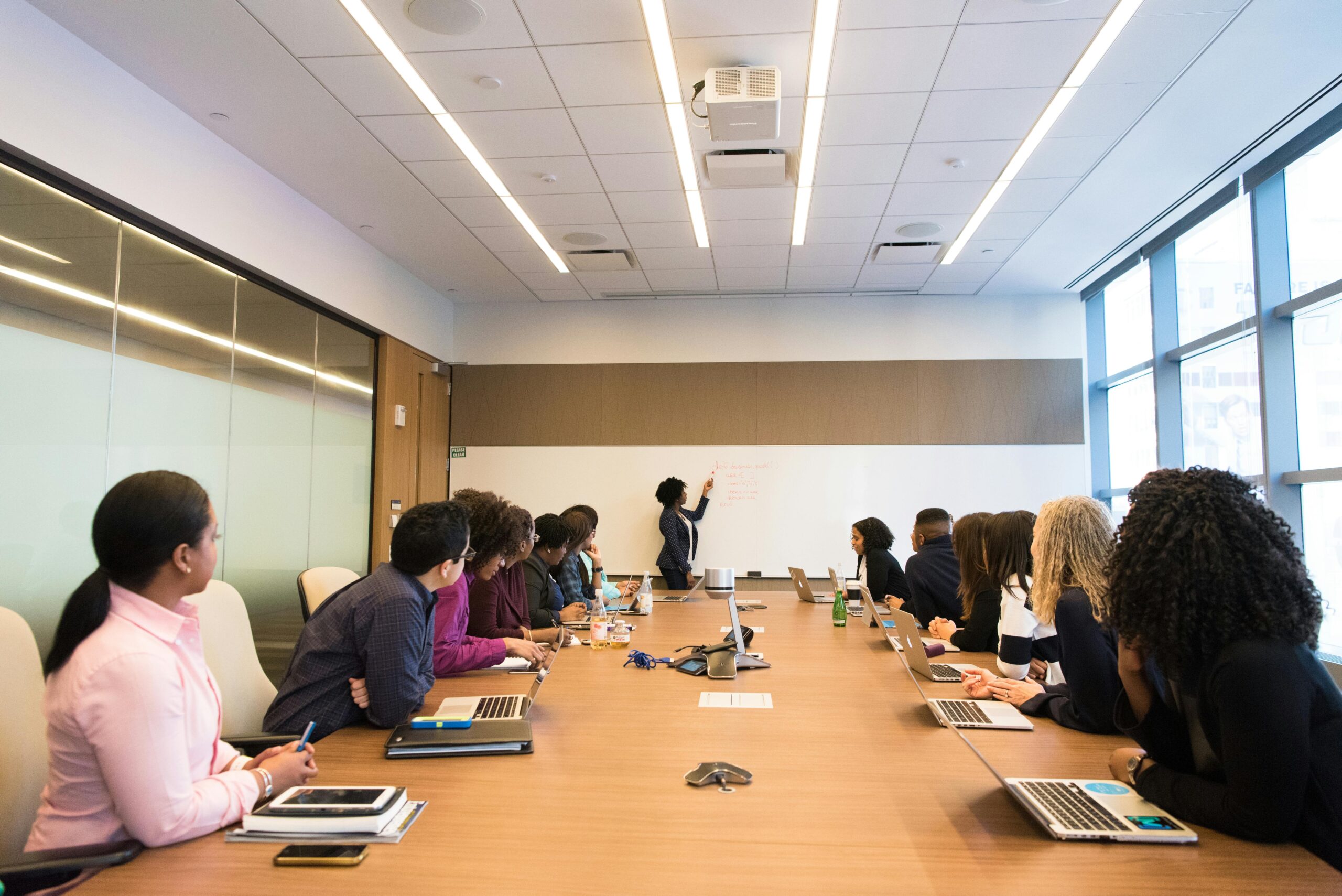 Employees in a conference room listening to their colleague.